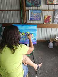 Katherine Shumaker painting Saturday at the Mooreland Free Fair.