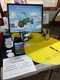 An original Tom Butters painting “Tractor Pull” that he painted at the 2019 Mooreland Fair. See the spectators in the clouds!