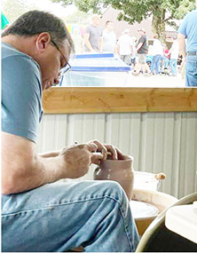 Mike Habzansky is throwing on the potter’s wheel this evening at the Mooreland Free Fair.